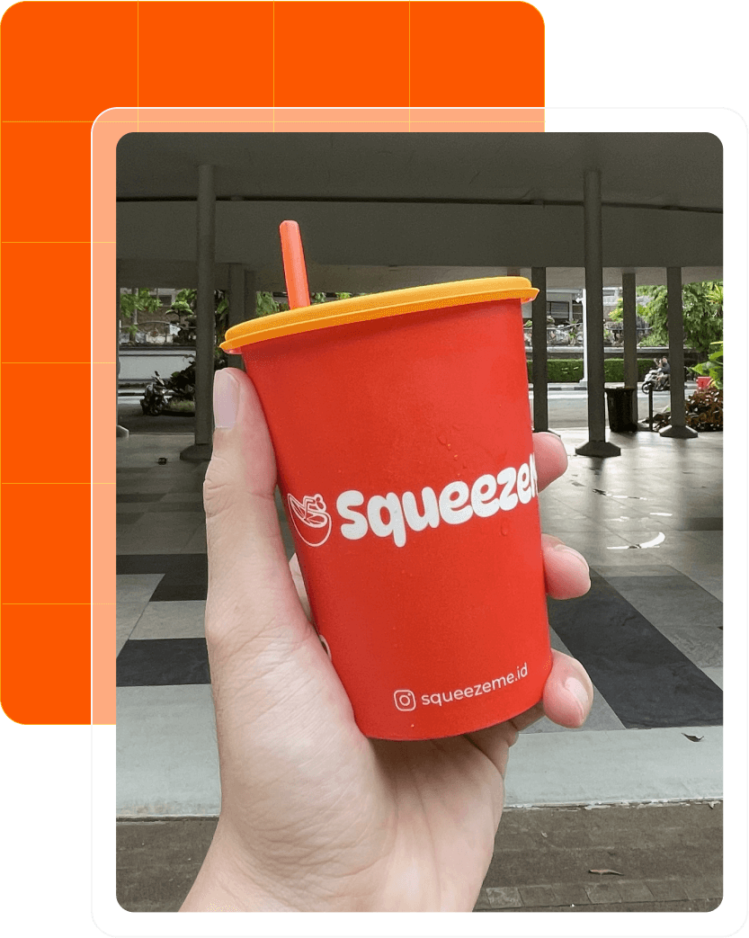 SqueezeMe Cup dipegang tangan - jus jeruk segar siap minum